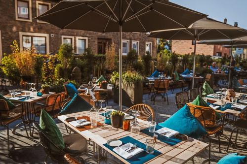 an outdoor patio with tables and chairs with umbrellas at Der LIPPISCHE HOF in Bad Salzuflen