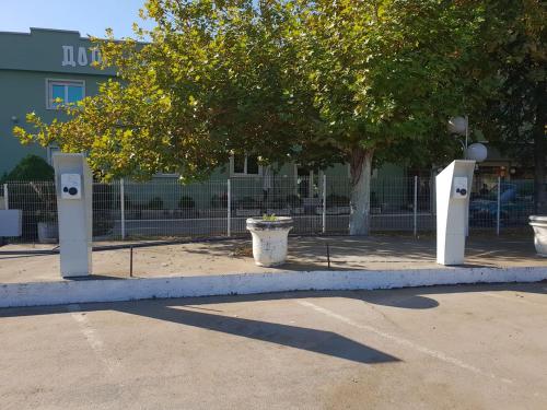 two parking meters in a parking lot next to a tree at Hotel Zeleni Vir in Niš