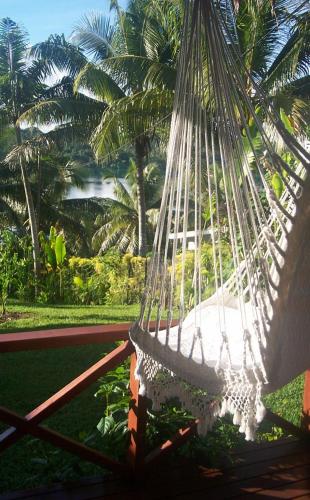 a hammock hanging from a palm tree at Seachange Lodge in Port Vila
