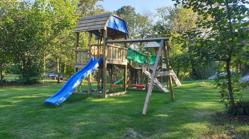 a wooden playground with a slide and a slideintend at Fenomen Plitvice Resort in Plitvička Jezera
