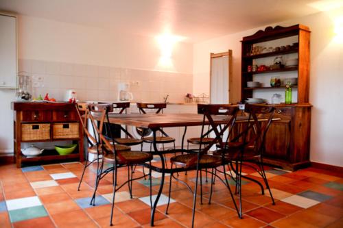 a kitchen with a wooden table and chairs at Villa Castel Maison Meublée in Rillieux