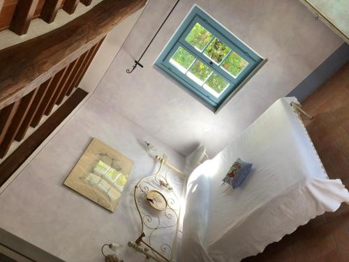 Una habitación con ventana y vistas panorámicas a una cama. en Antico Casale Silvia, en Alberoro