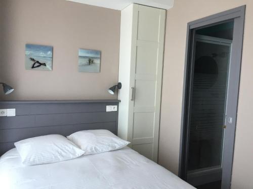a bedroom with a bed with two pillows on it at Le Cannier Hotel in La Seyne-sur-Mer