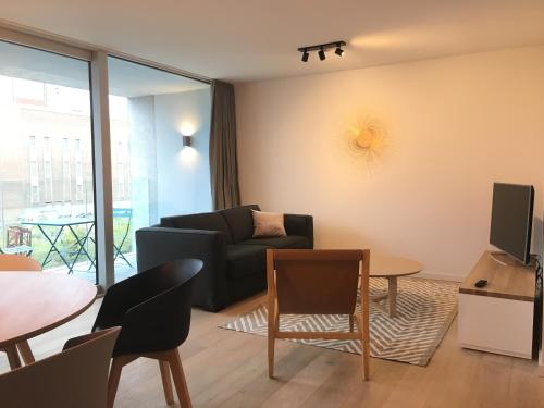 a living room with a couch and a table at Skyline Flats Gent in Ghent