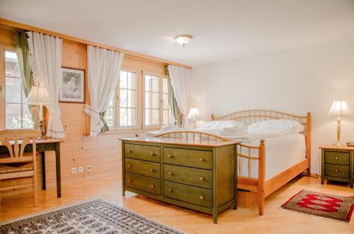 um quarto com uma cama com uma cómoda e uma secretária em Apartment Saphir - GRIWA RENT AG em Grindelwald