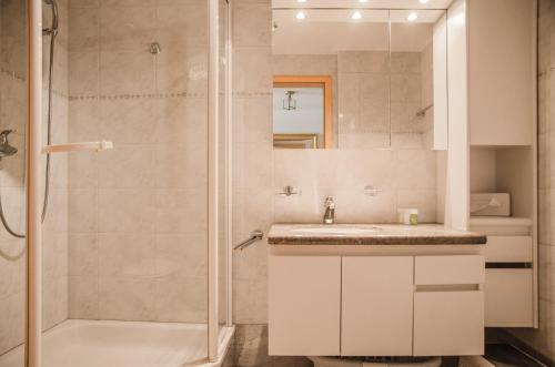 y baño con ducha y lavamanos. en Apartment Saphir - GRIWA RENT AG, en Grindelwald