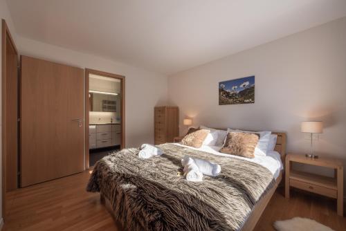 a bedroom with a large bed with towels on it at Chalet Am Acher 7 in Wengen