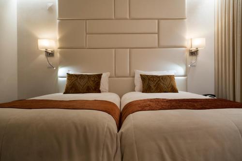 two beds sitting next to each other in a hotel room at Josefa D`Obidos Hotel in Óbidos