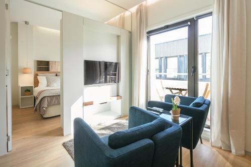 uma sala de estar com duas cadeiras azuis e uma televisão em Inn Oporto Downtown New Apartments no Porto