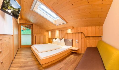 a bedroom with a bed in a room with a skylight at Pension Sonnleitn in Neustift im Stubaital
