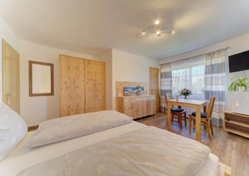 a bedroom with a bed and a desk and a table at Panoramablick in Mauth