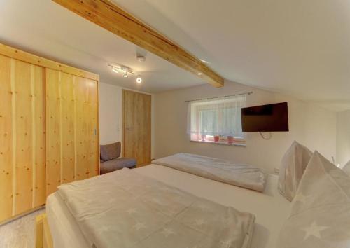 a bedroom with a bed and a flat screen tv at Panoramablick in Mauth