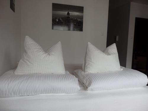 dwie białe poduszki siedzące na łóżku w obiekcie Szybowników 2 w mieście Piła
