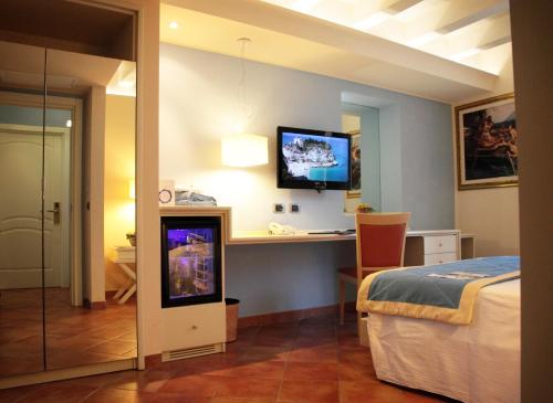 a bedroom with a bed and a desk and a tv at Portercole B&B in Tropea