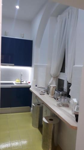 a white kitchen with a counter and a sink at CharmeRooms Palazzo Stampa in Bergamo