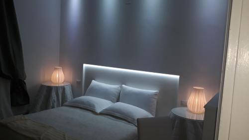 a bedroom with a bed with two lamps on it at CharmeRooms Palazzo Stampa in Bergamo