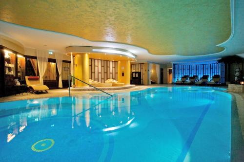 una gran piscina azul en un hotel en SEETELHOTEL Ahlbecker Hof, en Ahlbeck