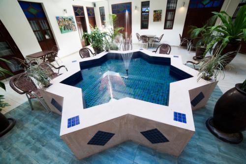 a swimming pool with a fountain in a building at Maru Maru Hotel in Zanzibar City