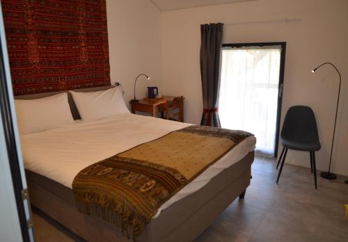 a bedroom with a bed and a chair and a window at Antica Sosta dei Viandanti in Cadenazzo