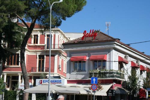 a street sign in front of a large building at Jolly City Center Hotel in Tirana