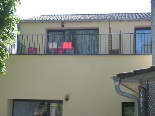 a balcony of a house with chairs on it at LES JARDINS DE LA GRANGE in Rezonville