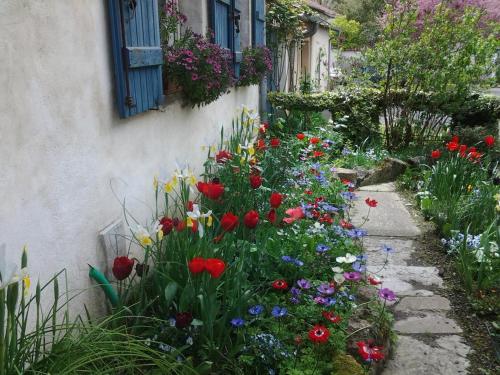 a garden with colorful flowers next to a building at Chambres d'Hôtes Aroha in Sorde-lʼAbbaye