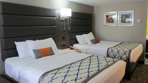 a hotel room with two beds in a room at Baymont by Wyndham Murfreesboro in Murfreesboro