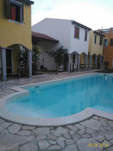 a large swimming pool in front of a building at Апартаменты с великолепным видом на горы in Viddalba