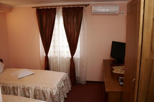 a hotel room with two beds and a window at Hotel Casa de Piatra in Scheia