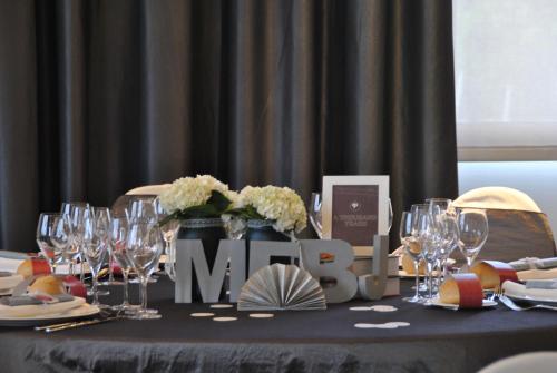 a table with wine glasses and a sign that says mum at Brea's Hotel in Reus