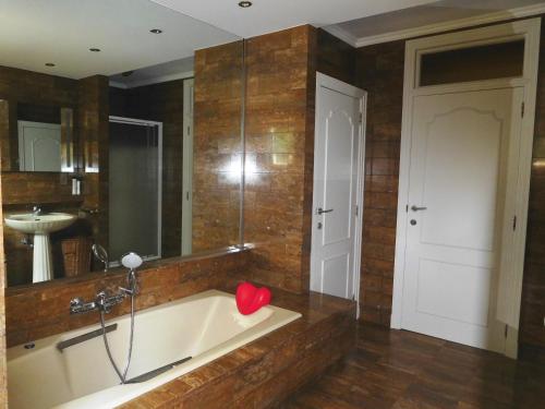 La salle de bains est pourvue d'une baignoire avec un cœur rouge. dans l'établissement Suite Horatio, à Heusden-Zolder