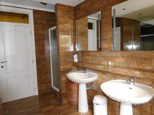a bathroom with two sinks and a mirror at Suite Horatio in Heusden - Zolder