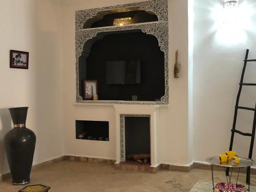a living room with a fireplace with a tv above it at Dar Christine in Marrakesh