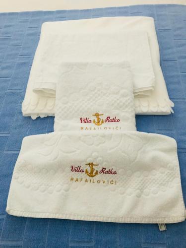 three white towels sitting on top of a bed at Guest House Ratko in Rafailovici