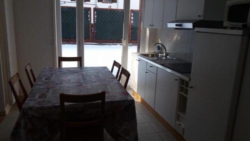 une cuisine avec une table et des chaises et une cuisine avec un évier dans l'établissement Max 's Siusi Apartement, à Alpe di Siusi