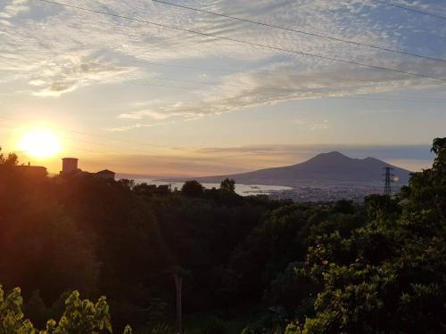 a sunset over a city with a mountain in the background at B&B Villa Catiè in Castellammare di Stabia