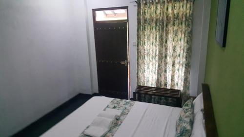 a small bedroom with a bed and a window at Grace Green Ville in Negombo