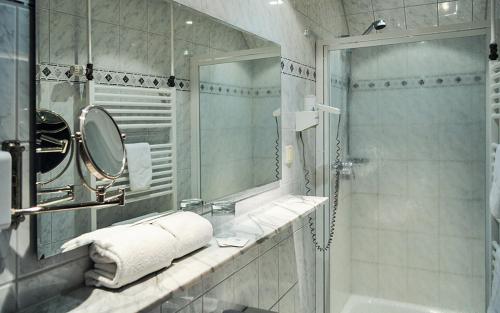 a bathroom with a shower and a sink and a mirror at Hotel-Restaurant Schmachtenbergshof in Essen