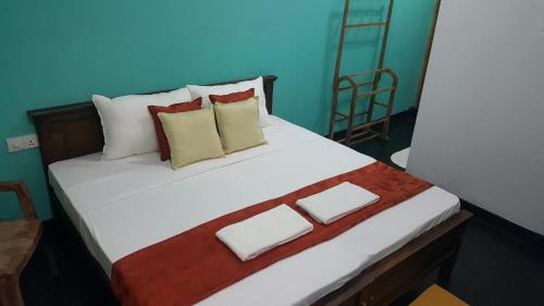 a bedroom with a large white bed with pillows at Grace Green Ville in Negombo