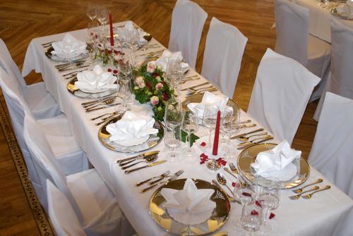 a table with a white table cloth with glasses and flowers at Hotel-Restaurant Schmachtenbergshof in Essen