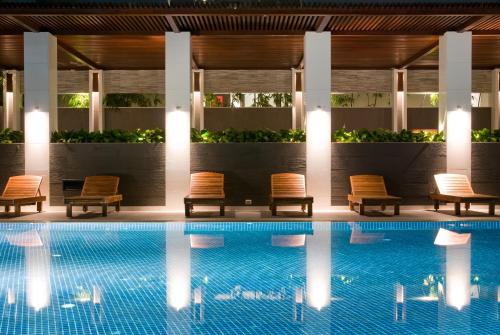 a pool at a hotel with chairs next to it at Amaranth Suvarnabhumi Hotel - Free Suvarnabhumi Airport Shuttle in Lat Krabang