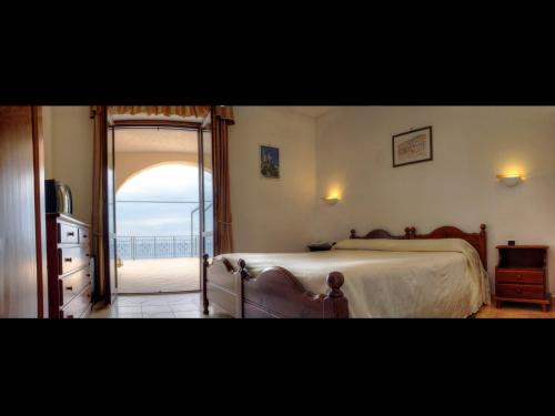 a bedroom with a bed and a door to a balcony at Hotel Club San Diego in Maratea