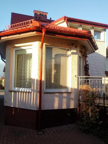 a house with an awning on the side of it at Pokoje PETRA pod Bocianem in Supraśl