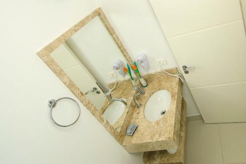 y baño con lavabo y espejo. en VIDA MANSA, en Bombinhas
