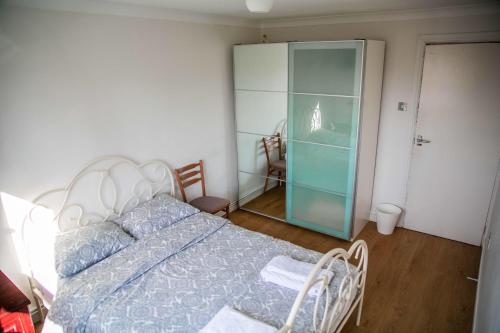 Double bedroom in ashared flat في سوتون: غرفة نوم بسرير وخزانة زجاجية