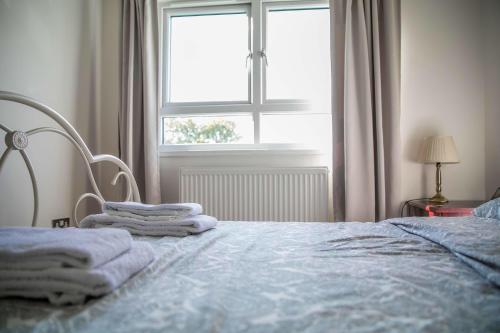 Double bedroom in ashared flat في سوتون: غرفة نوم عليها سرير وفوط