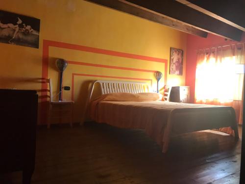 a bedroom with a bed with a red and yellow wall at Gelsomino in Morano Calabro