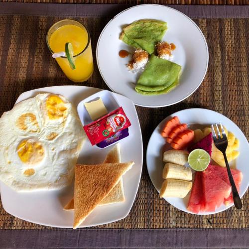 three plates of breakfast food on a table at Betutu Bali Villas in Ubud