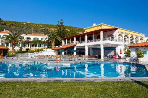 a large swimming pool in front of a building at Arion Hotel in Kokkari