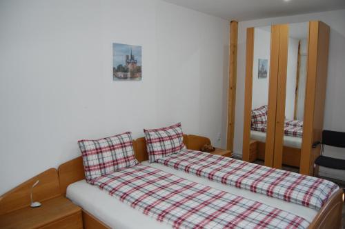 a bed with a plaid pillow on top of it at Vila Tadi in Avrig